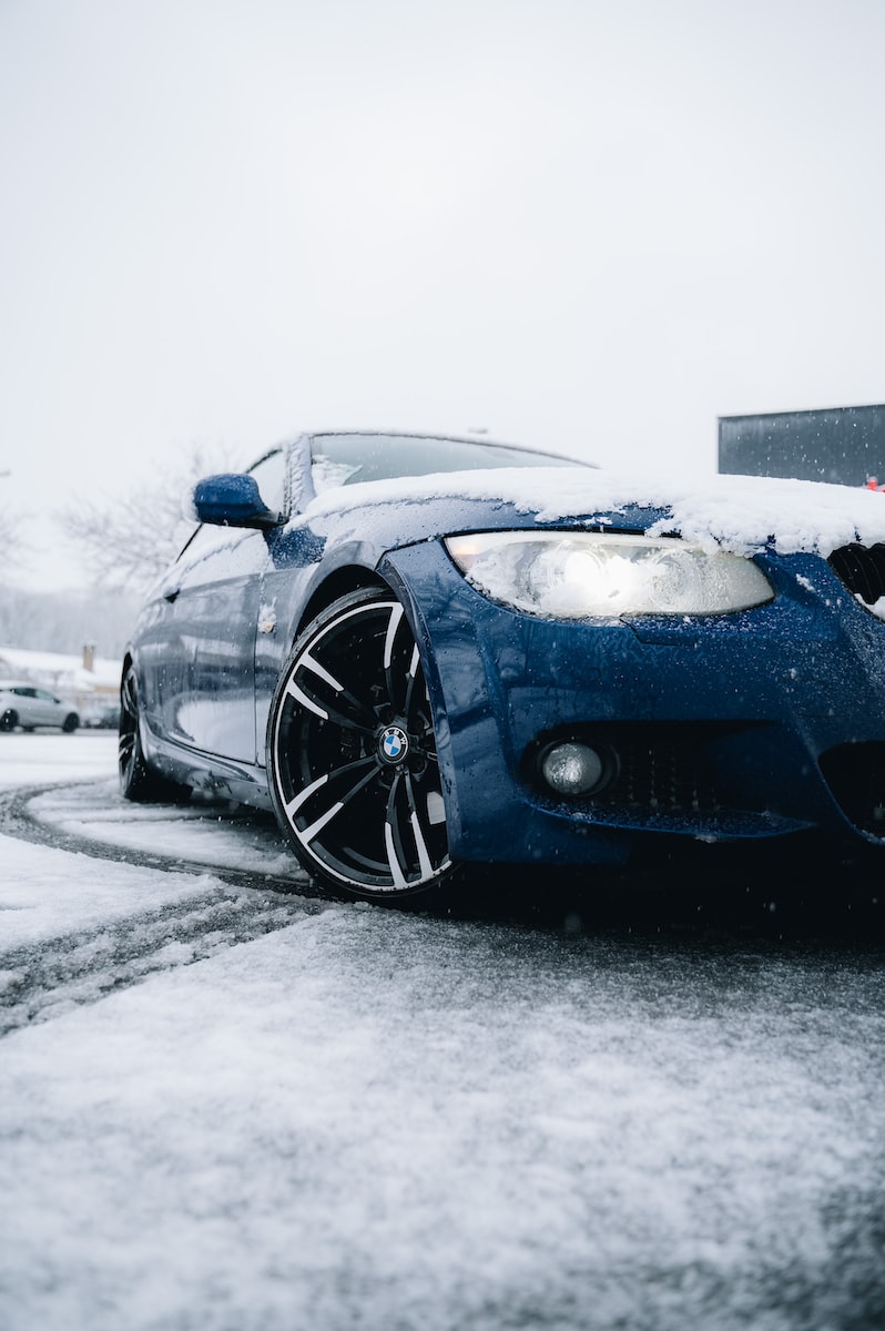 a blue car parked on a snowy street