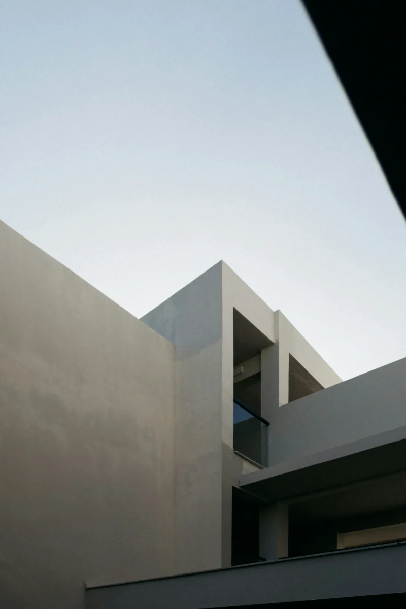 Minimalist white concrete building under a vivid blue sky in 4K resolution, ideal for mobile AMOLED wallpaper and phone lock screens.