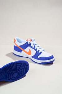 a pair of blue and orange sneakers on a white surface